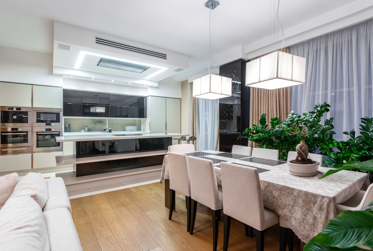 A light-filled dining space with a wooden table and upholstered chairs